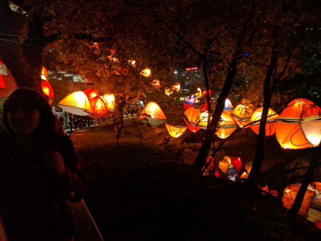 Weird Austin: Creek show with lighted tents floating above the water in waller creek.