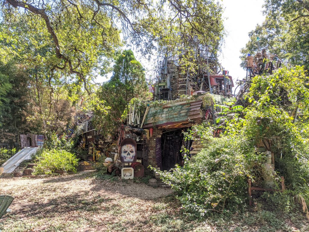 Austin's Weird Cathedral of Junk, covered in greenery