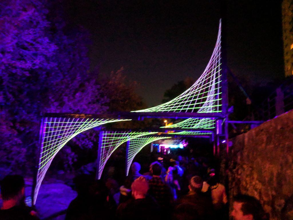 Austin Immersive Art in Creek Show. Glowing lines above crowd in waller creek.