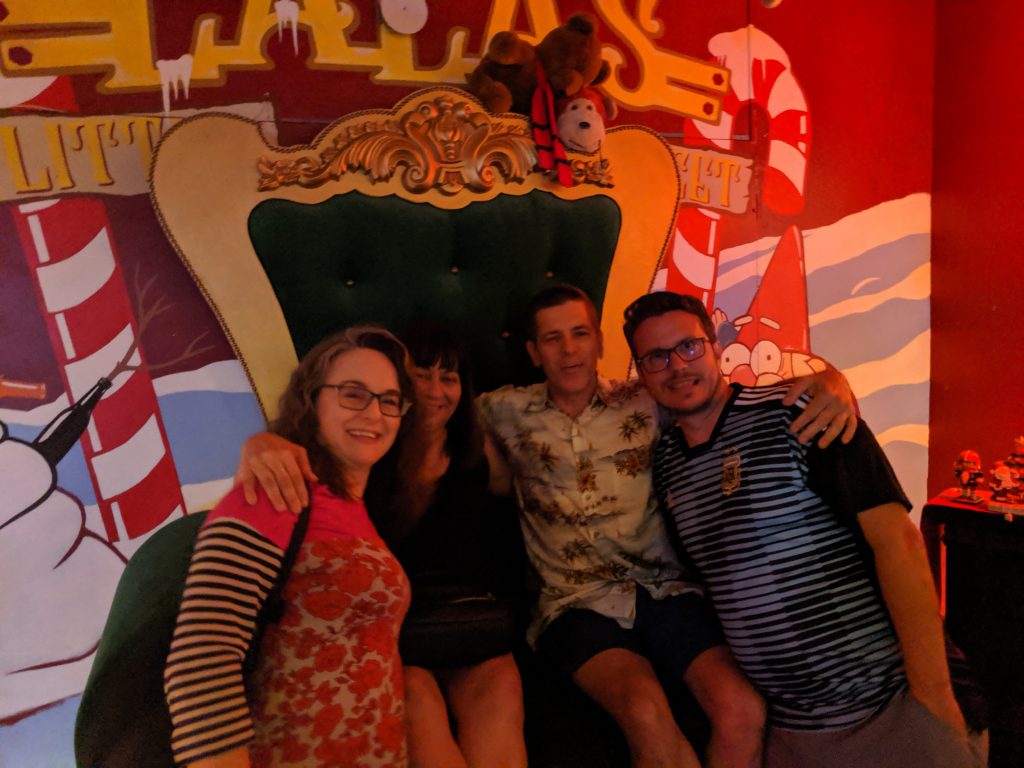 Four people posing on Santa's throne at Lala's Little Nugget.
