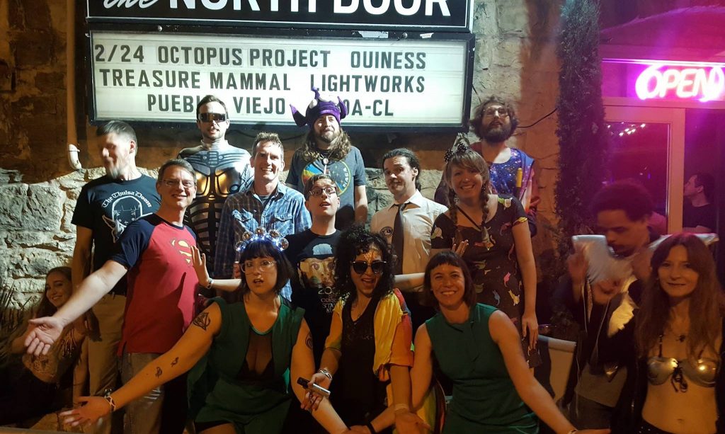 band members in front of marquee
