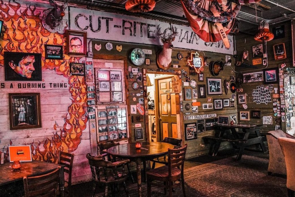 Vibrant interior of the Mean Eyed Cat bar adorned with Johnny Cash posters, photos, quotes, and memorabilia.