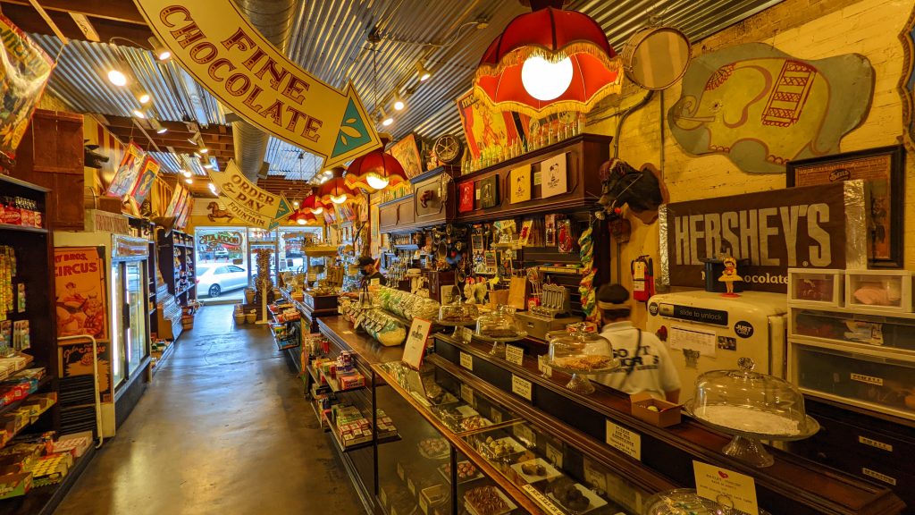 Interior of Big Top Candy Shop in Austin. A counter showcasing chocolates and shelves with a variety of packaged candies.